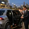 Post Match MCG Chauffeur Transfers with a professional chauffeur assisting passengers beside a luxury silver Mercedes-Benz GLE SUV outside the MCG